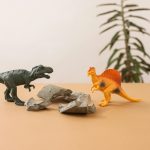 Plastic dinosaur toys on a simple background, creating a playful prehistoric scene.