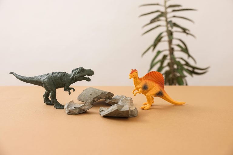 Plastic dinosaur toys on a simple background, creating a playful prehistoric scene.